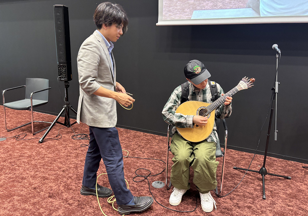 イベント後、山本氏に珍しいポルトガルギターを体験させてもらう学生。
